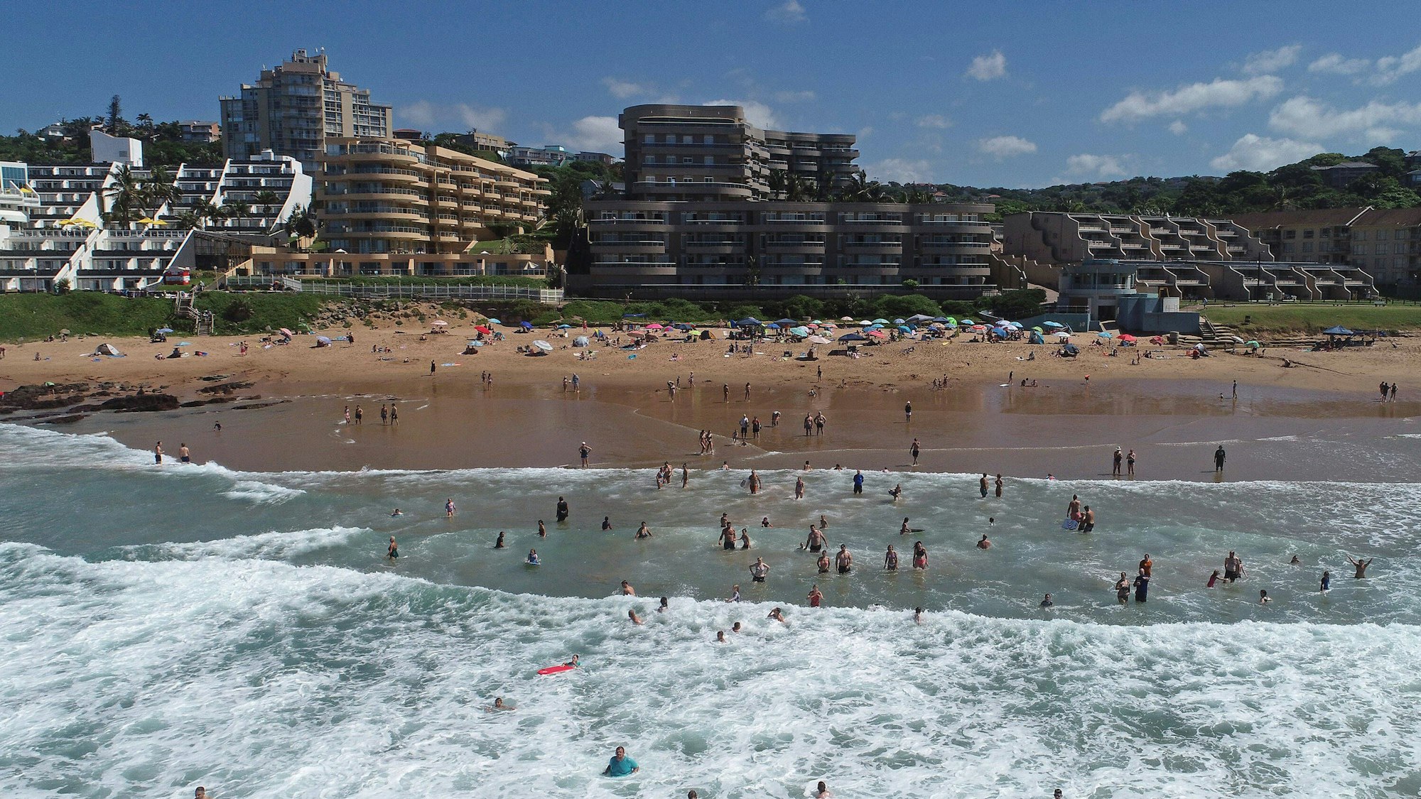 Blick vom Meer auf einen belebten Strand in Durban, Südafrika.