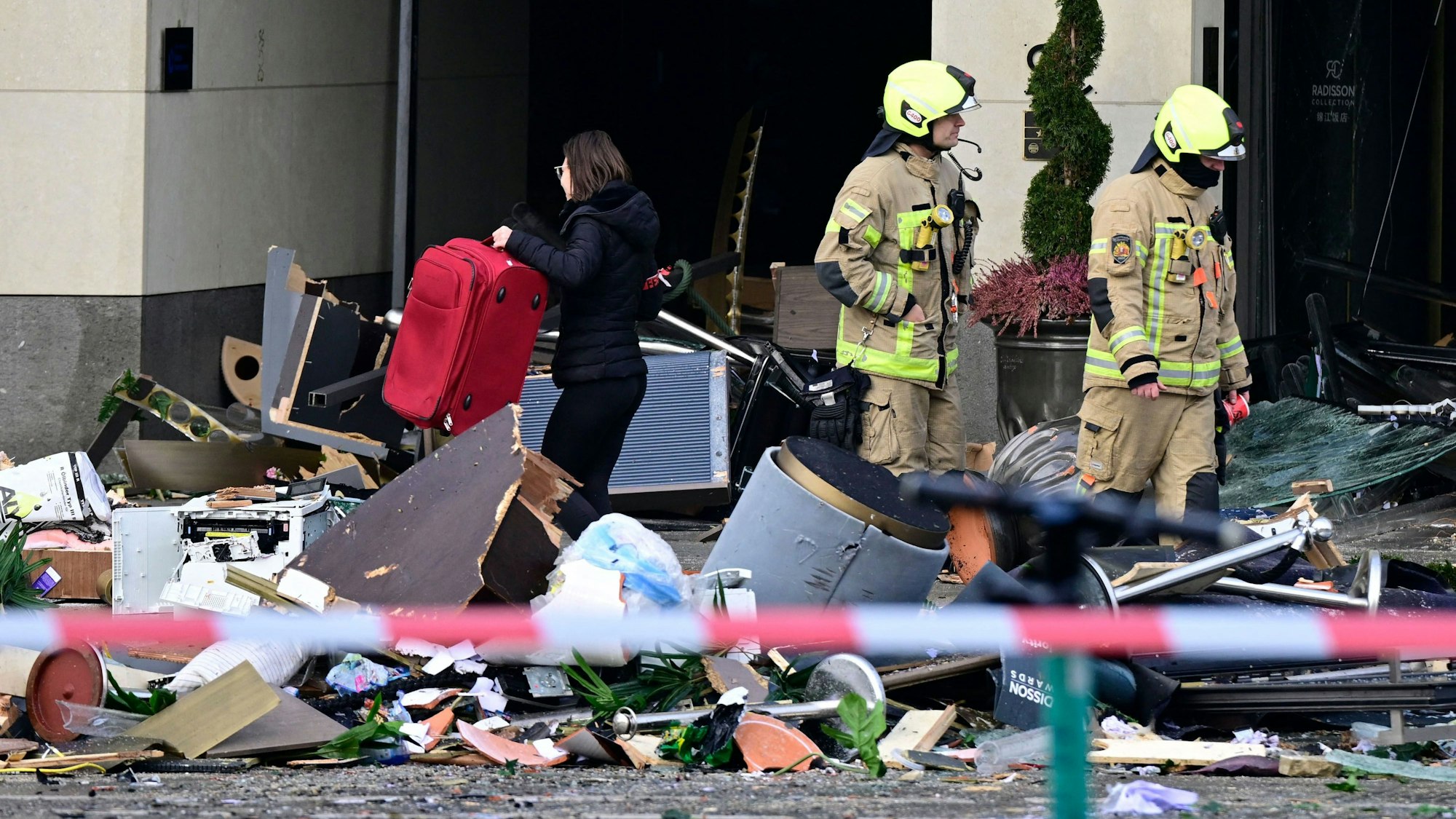 Berliner Feuerwehrleute stehen in dem Schutthaufen am Freitag, der auf die Straße gespült wurde, nachdem das Aquarium in einem Berlin Hotel geplatzt ist.