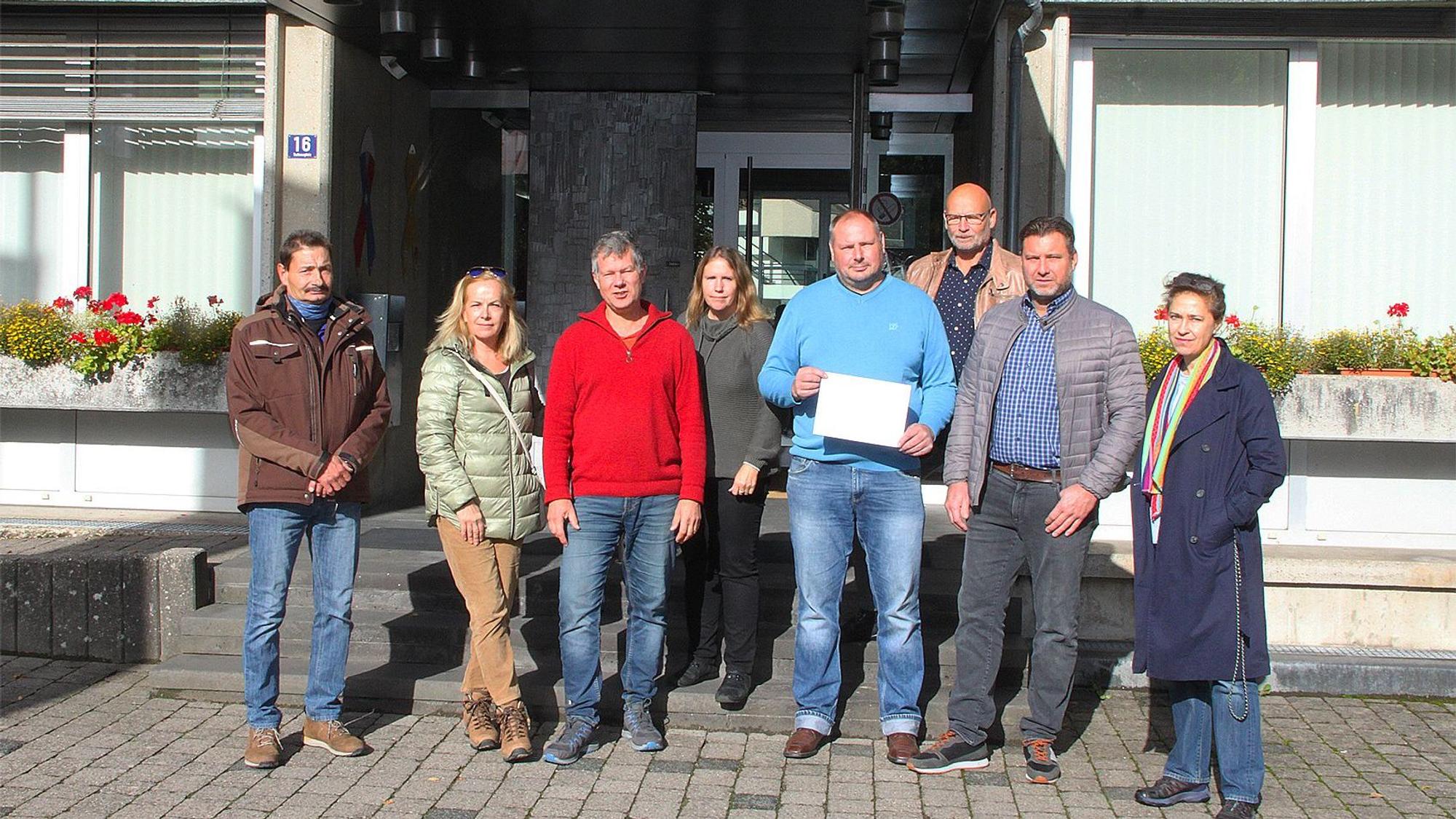 Bürgerinnen und Bürger von Blankenheim stehen mit dem Anmeldebogen des Bürgerbescheides vor dem Rathaus.
