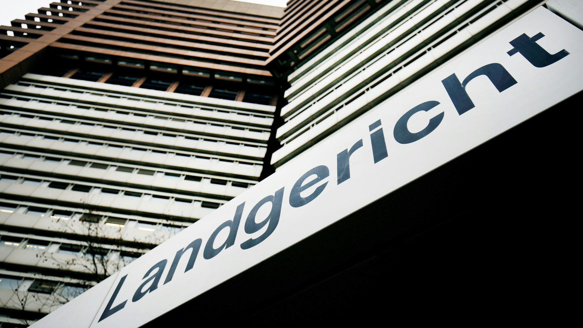 Das Bild zeigt die Außenansicht des Landgerichts Köln mit dem Schriftzug „Landgericht“ über dem Gebäudeeingang.
