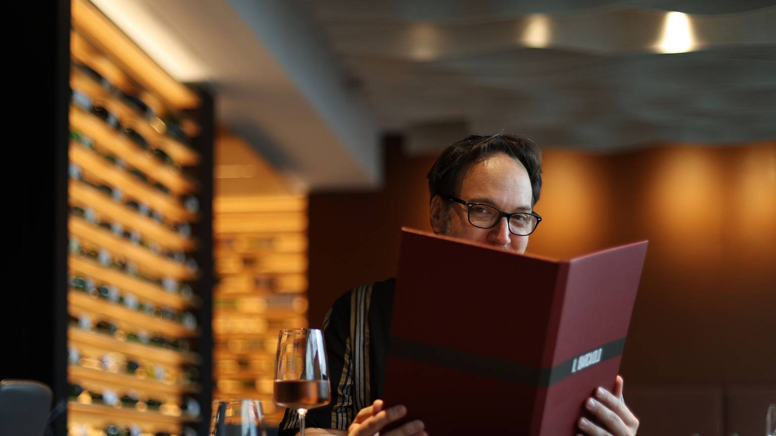 Mann mit Brille schaut in eine Speisekarte
