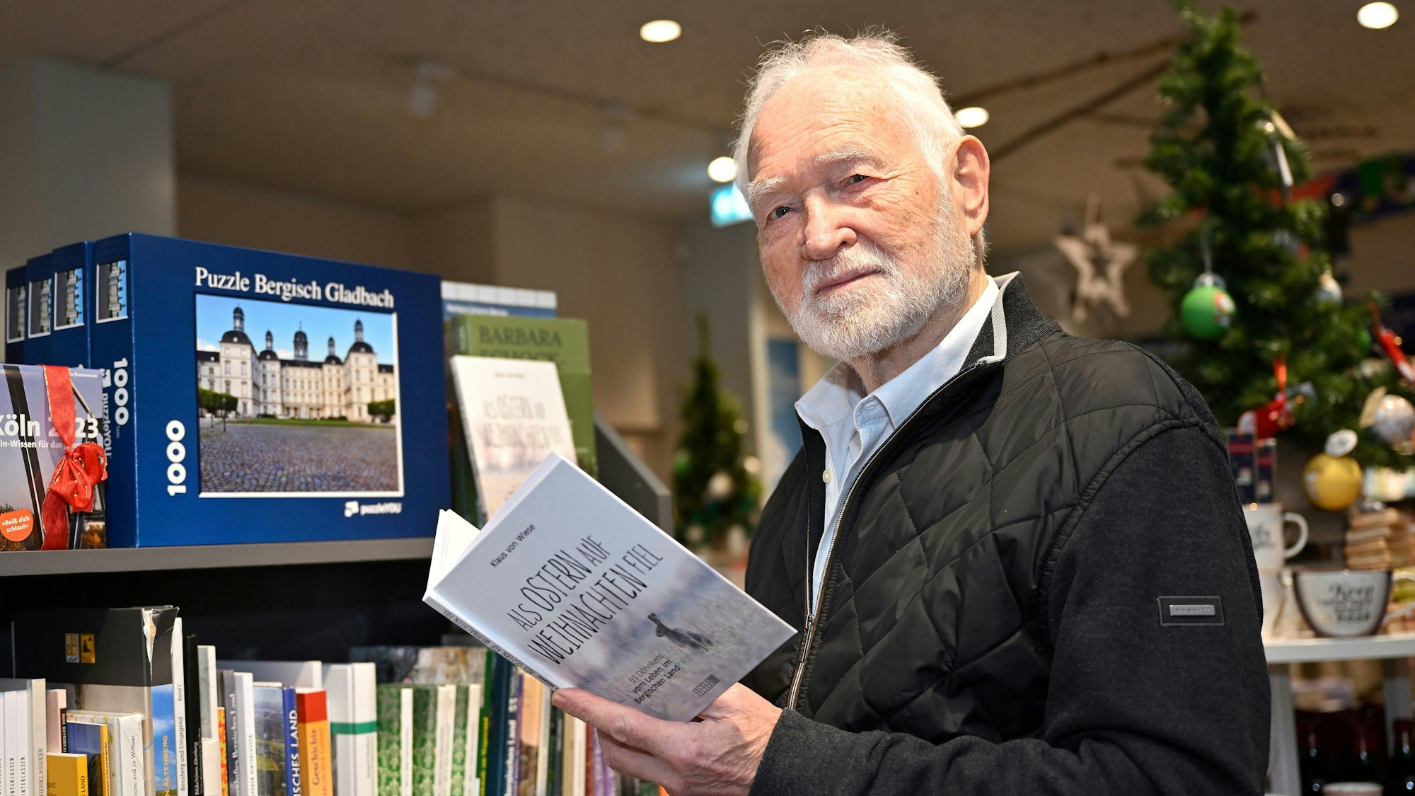 Klaus Dewes steht in der Buchhandlung Thalia und hält sein aufgeklapptes Buch in der Hand.