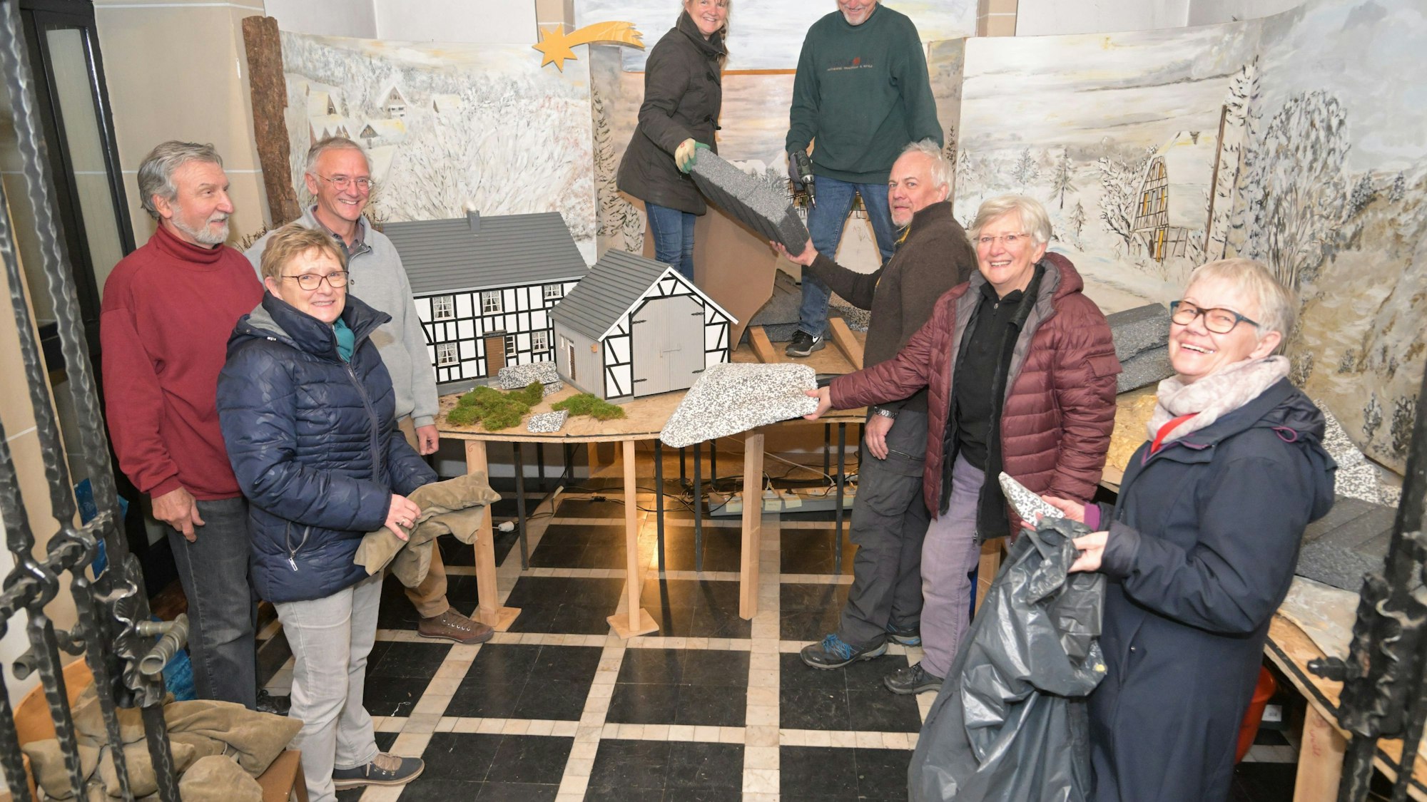 Das Foto zeigt die Helfer beim Aufbau der Krippe in der Kirche Zur Schmerzhaften Mutter in Kürten-Biesfeld