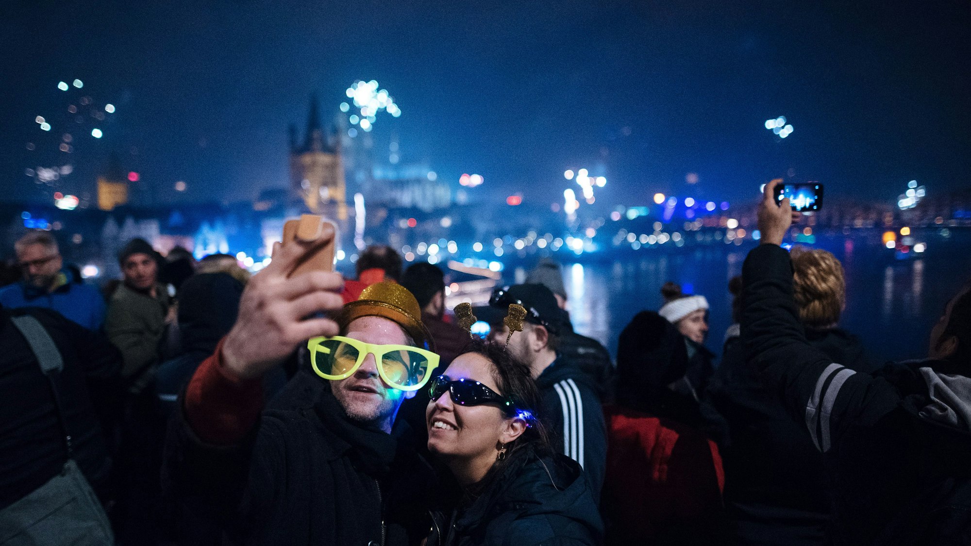 Auf der Hohenzollernbrücke fotografieren sich zwei junge Menschen. Im Hintergrund ist der Dom zu sehen. Das Foto wurde an Silvester 2018 aufgenommen.
