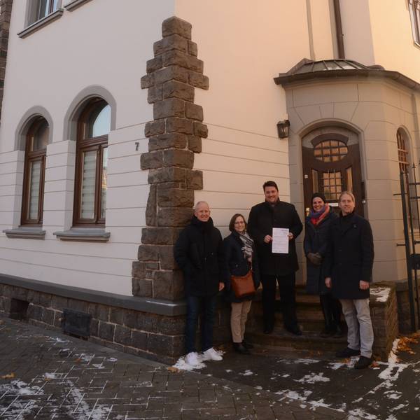 Der Technische Beigeordnete Walter Schaaf, Denkmalpflegerin Beate von Berg und Bürgermeister Alexander Biber übergeben den Förderbescheid.
