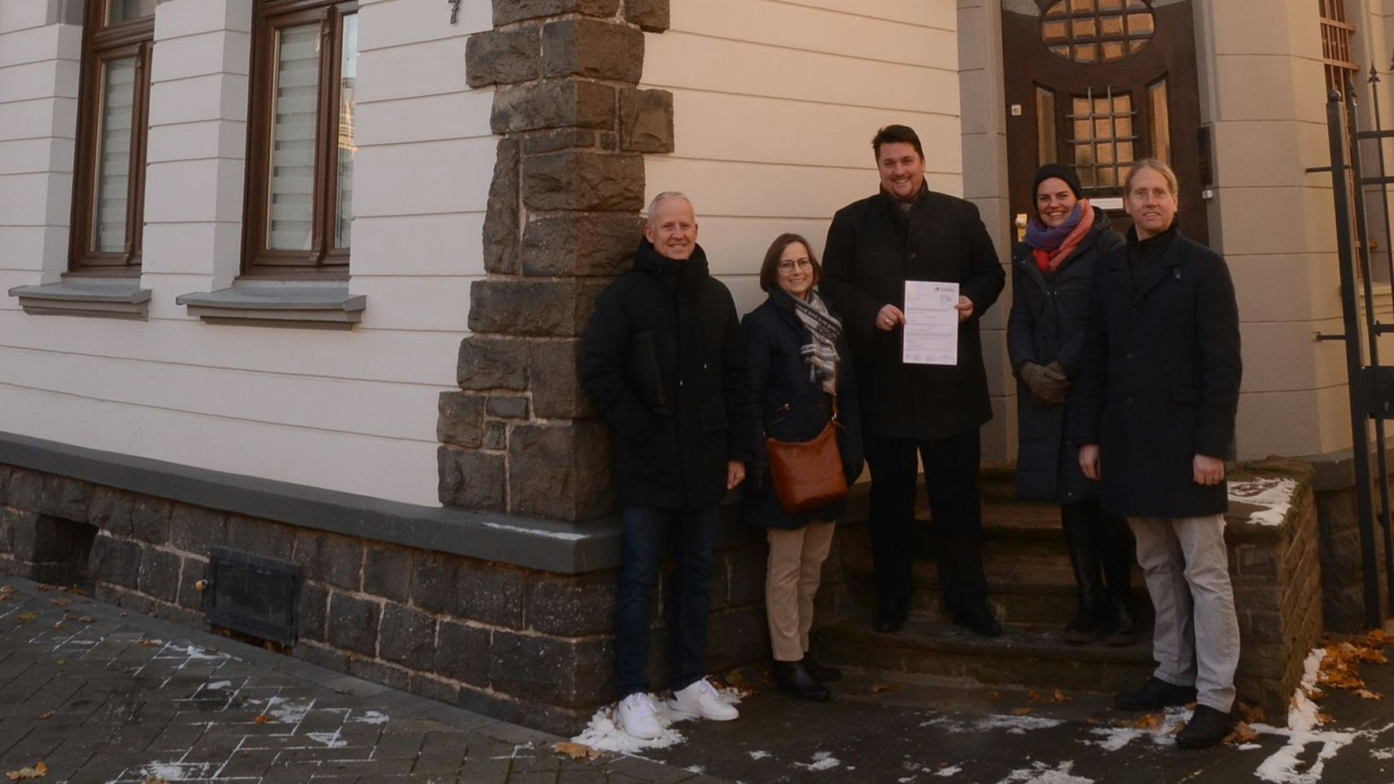 Der Technische Beigeordnete Walter Schaaf, Denkmalpflegerin Beate von Berg und Bürgermeister Alexander Biber übergeben den Förderbescheid.