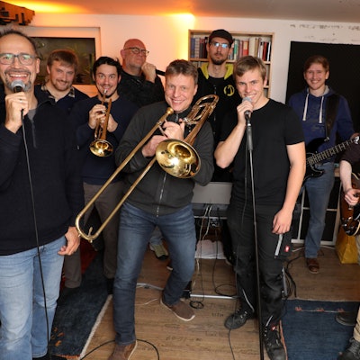 Die Band steht beisammen und posiert für die Kamera.