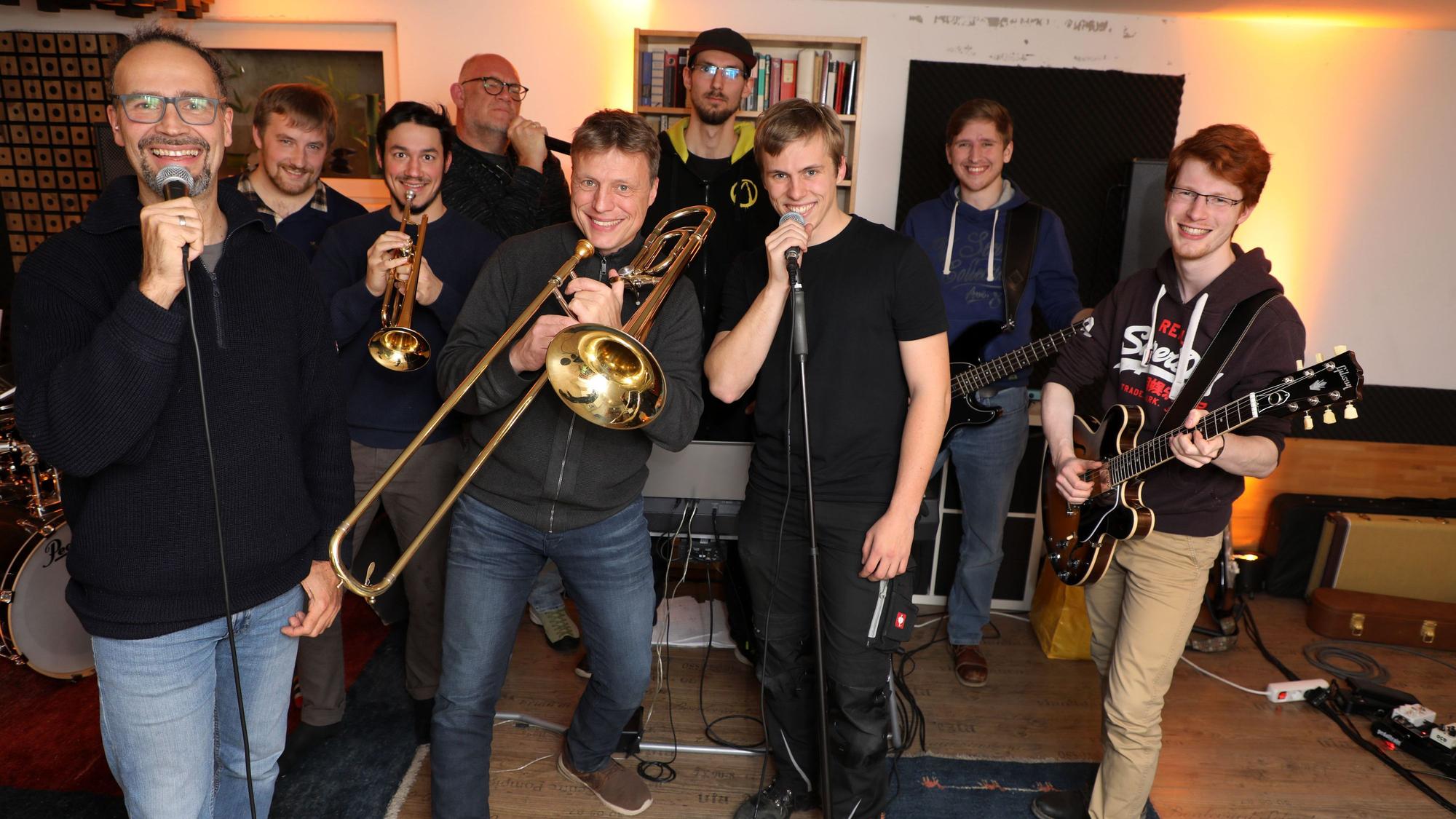 Die Band steht beisammen und posiert für die Kamera.