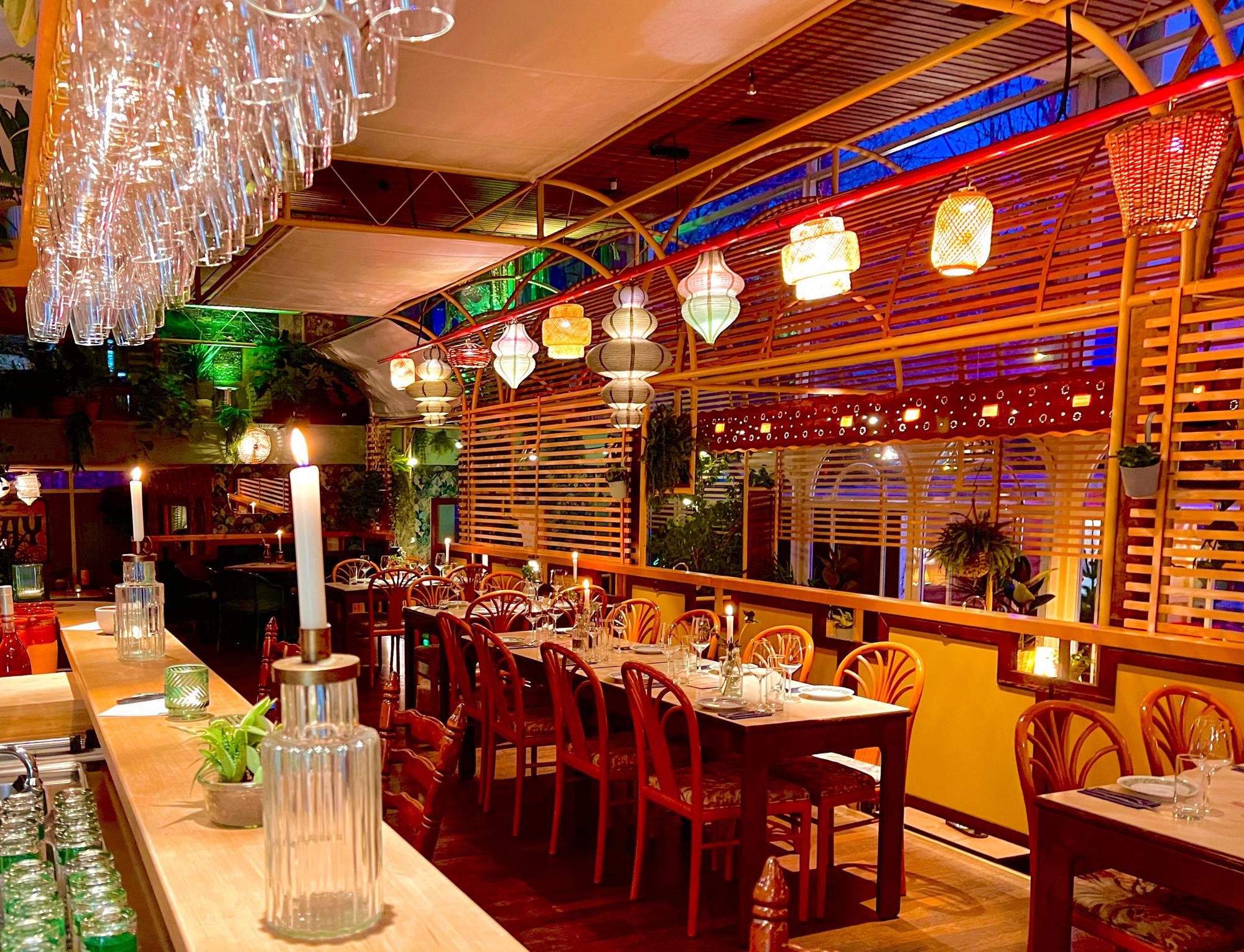 Die Inneneinrichtung des Bistros: Holzstühle, Kerzen und bunte Lampen erinnern an die 70er Jahre.