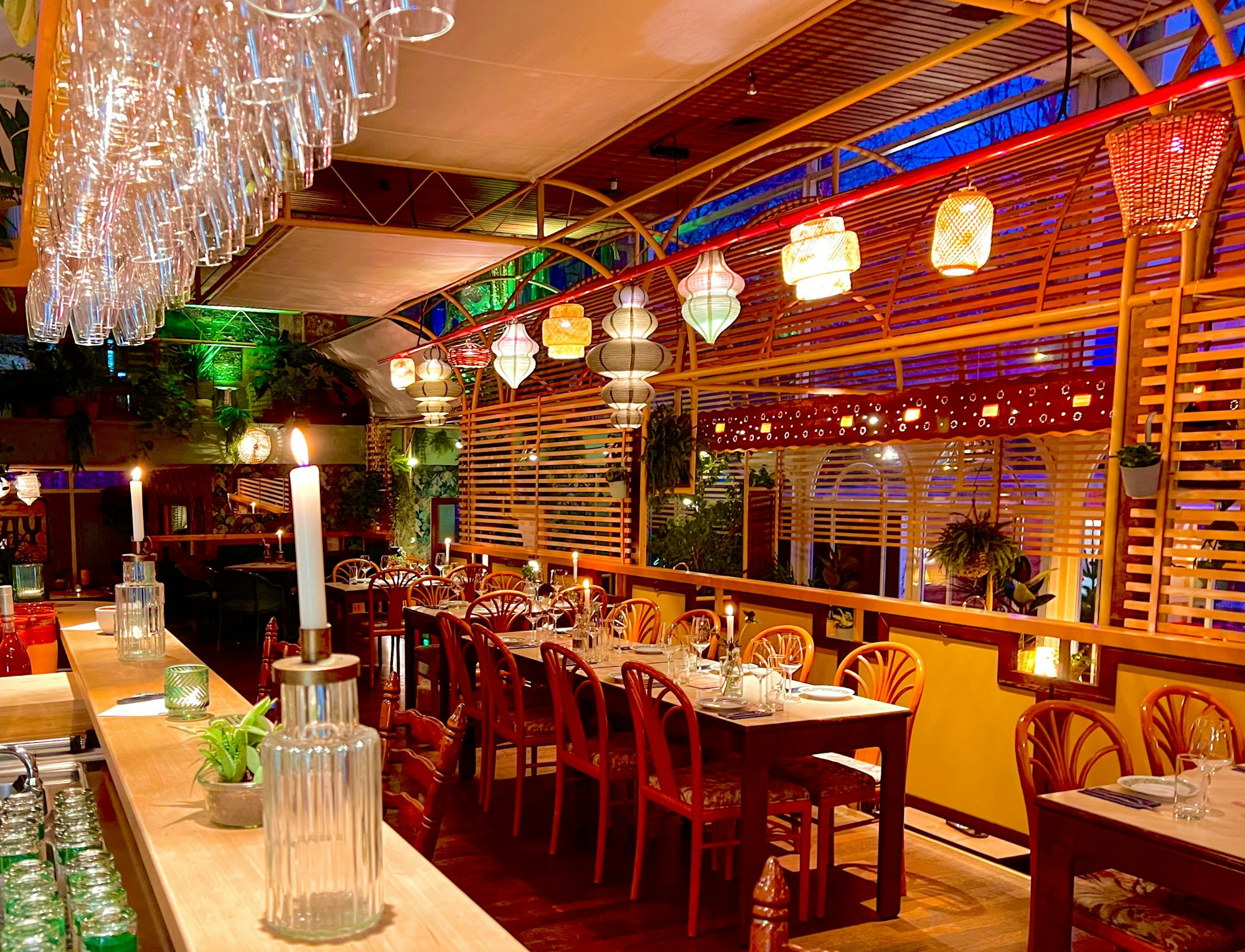 Die Inneneinrichtung des Bistros: Holzstühle, Kerzen und bunte Lampen erinnern an die 70er Jahre.