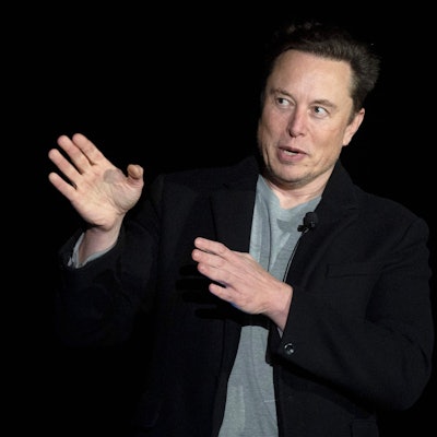 Elon Musk spricht während einer Pressekonferenz. Er gestikuliert dabei.