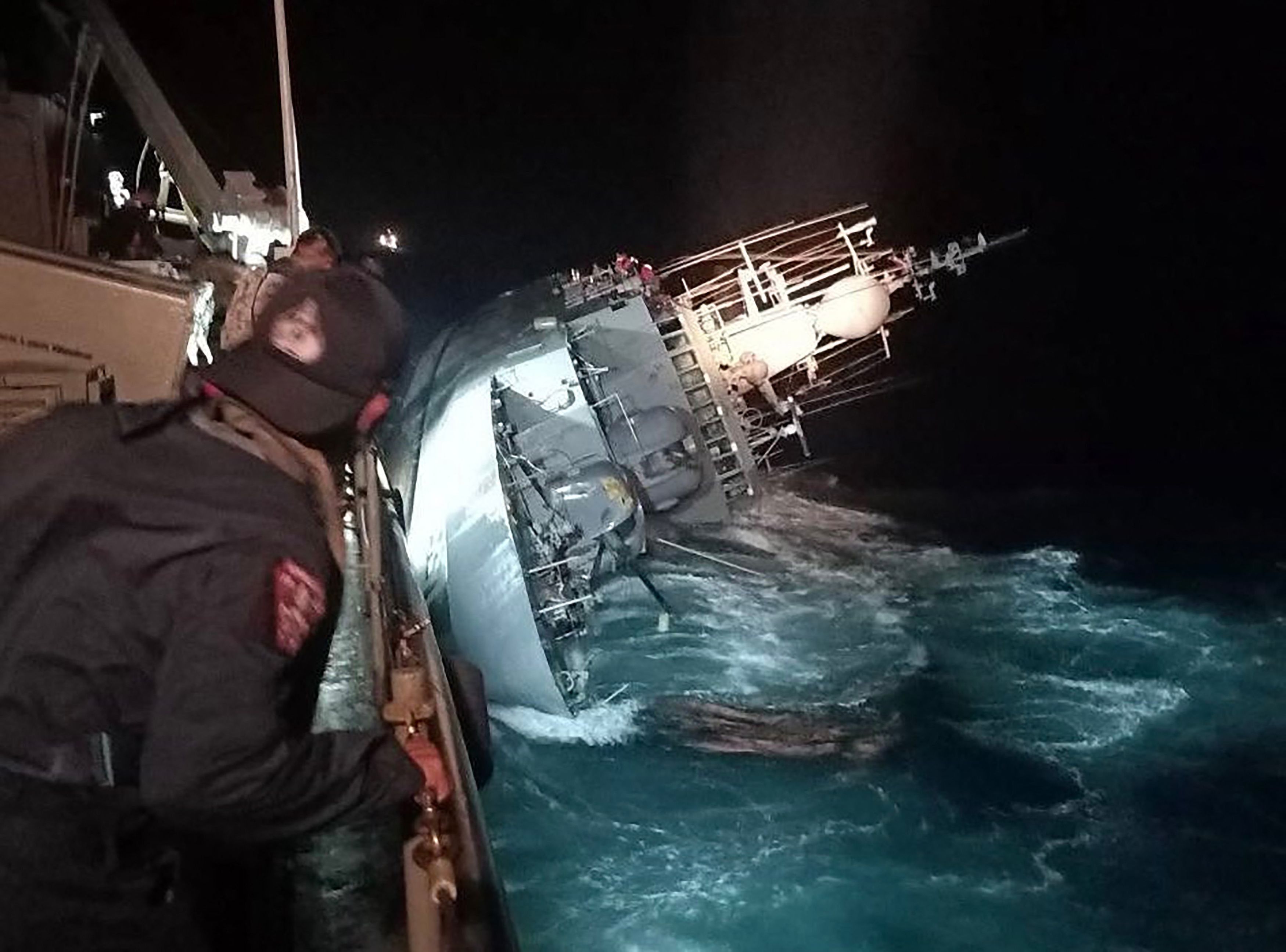 Das Foto zeigt das gekenterte thailändische Marineschiff, Einsatzkräfte beobachten die HTMS Sukhothai.