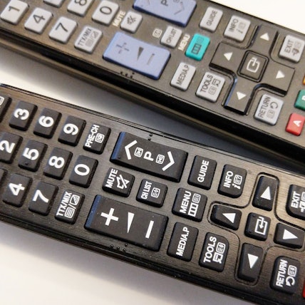 Zwei Fernbedienungen von Samsung liegen auf einem Tisch.