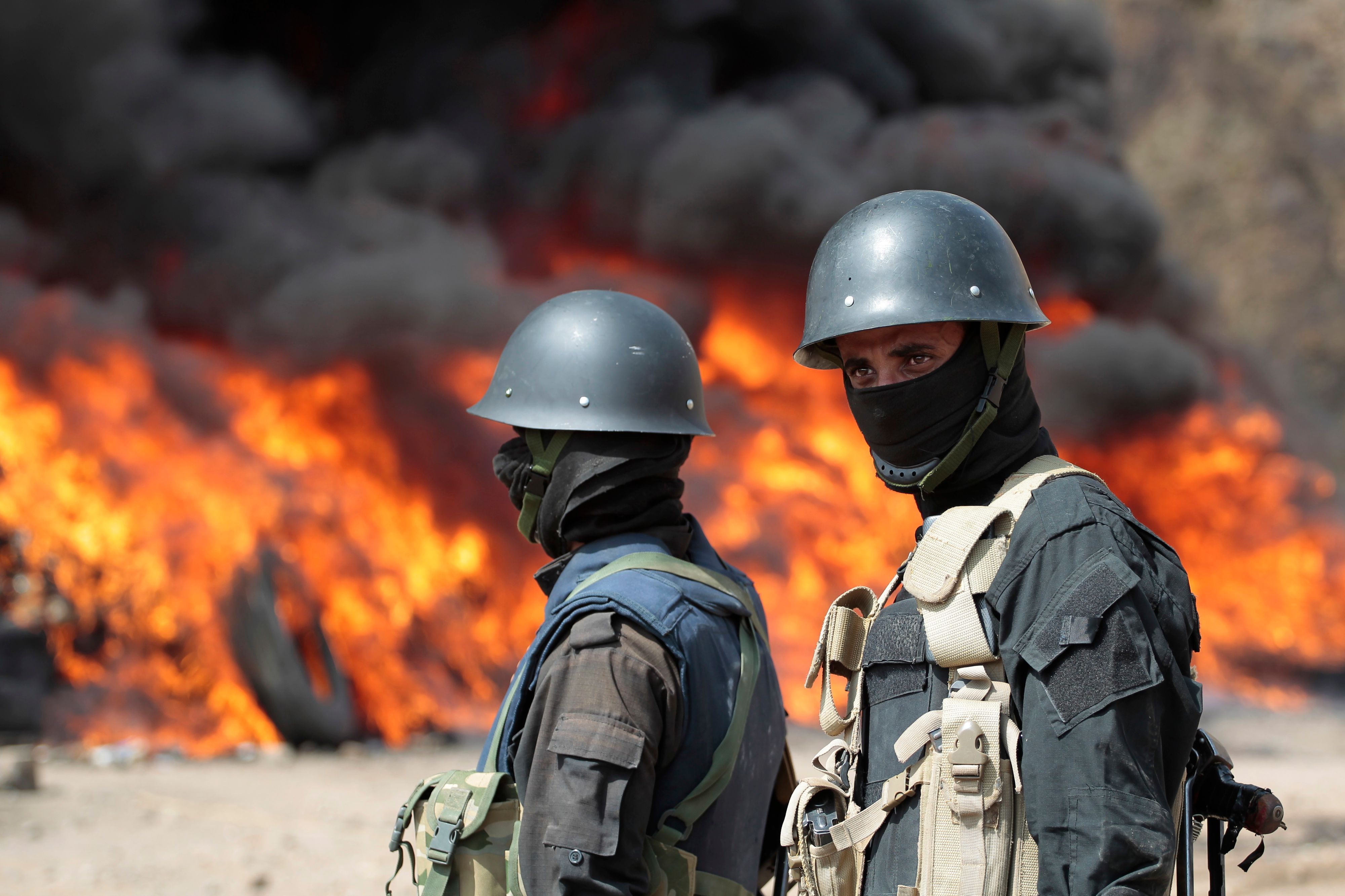 Soldaten stehen Wache, während im Hintergrund Flammen lodern (Symbolbild)picture alliance/dpa