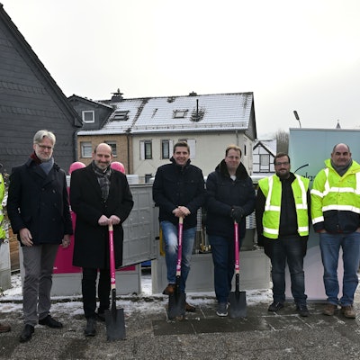 Die Beteiligten des Glasfaserausbaus in Overath stehen in einer Reihe, drei von ihnen haben einen Spaten in der Hand.