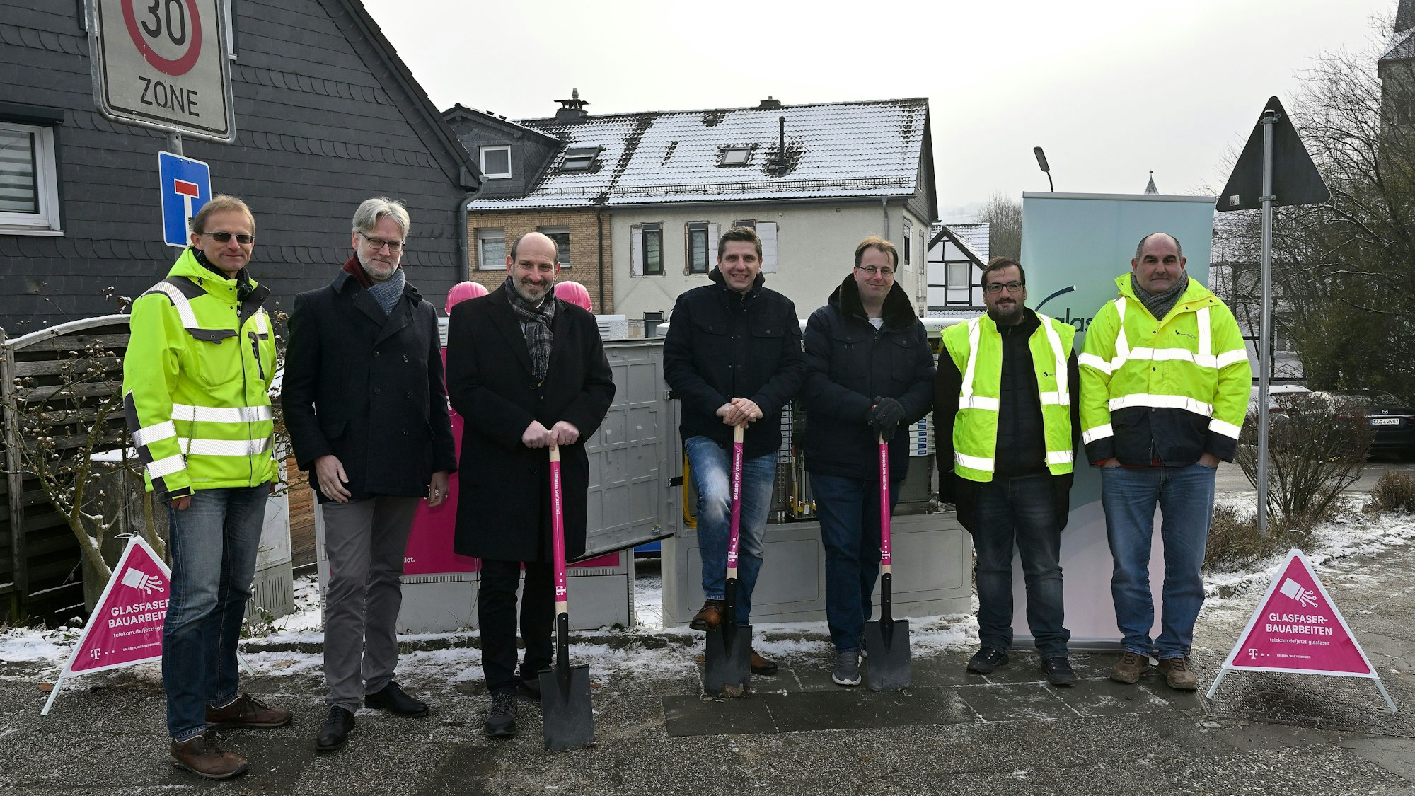 Die Beteiligten des Glasfaserausbaus in Overath stehen in einer Reihe, drei von ihnen haben einen Spaten in der Hand.