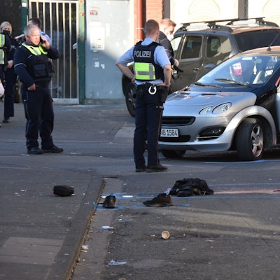 Polizisten stehen an der Bamberger Straße vor einem Auto, aus dem ein Mann gezerrt wurde.