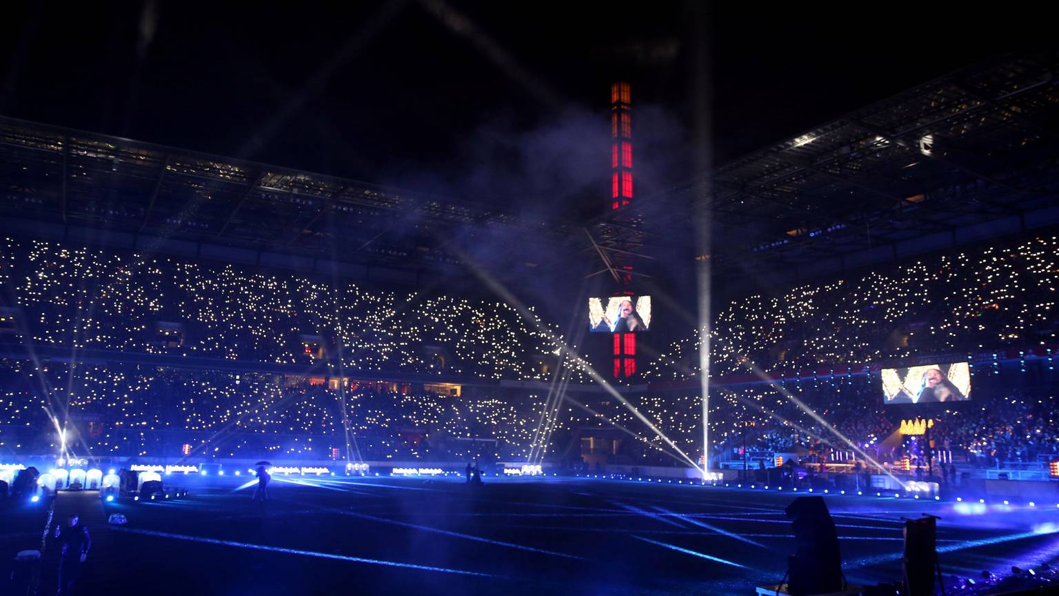 Tausende Lichter erstrahlen auf den vollen Tribünen des abgedunkelten Rheinenergie-Stadions in Köln bei der Mitsing-Veranstaltung "Loss mer Weihnachtsleeder singe" 2019.