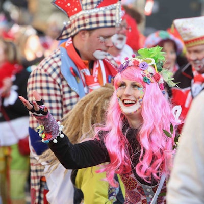 Die „Ultras GKKG“ in Karnevalskostümen, in der Mitte eine Frau mit pinker Perücke.