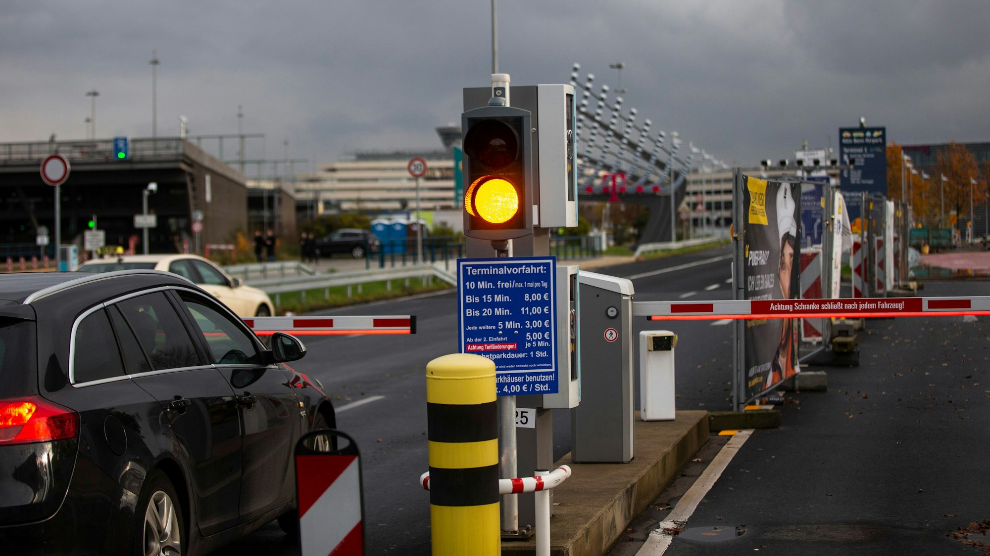 Ein Auto hält vor einer Schranke am Flughafen Köln-Bonn. Eine Ampel steht auf Gelb.