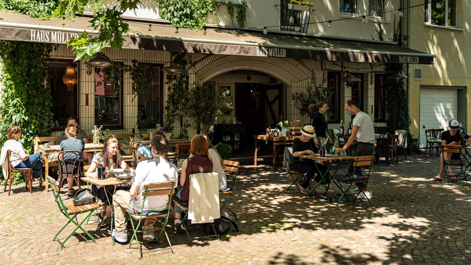 Das Restaurant Haus Müller in der Kölner Südstadt, Blick auf den Außenbereich mit Gästen
