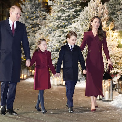 William und Kate Middleton, Prinz und Prinzessin von Wales, gehen mit ihren Kindern Prinzessin Charlotte und Prinz George. Im Hintergrund sind Weihnachtsbäume zu sehen.