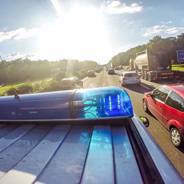 Ein Einsatzwagen fährt auf einer Autobahn vorbei an anderen Autos.