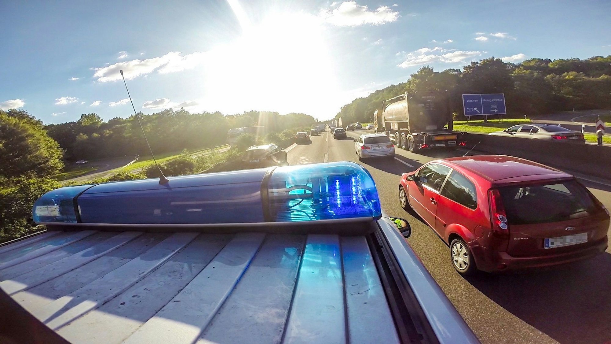 Ein Streifenwagen und andere Autos fahren auf der Autobahn.