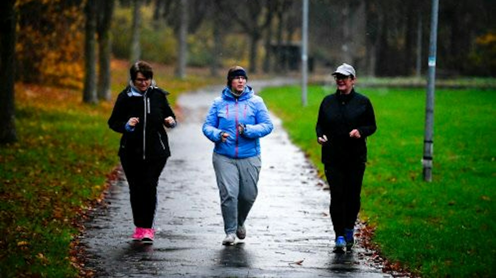 Drei warm eingepackte Frauen, darunter auch Redakteurin Julia Reuß, slowjoggen im Mühlenpark in Kommern.