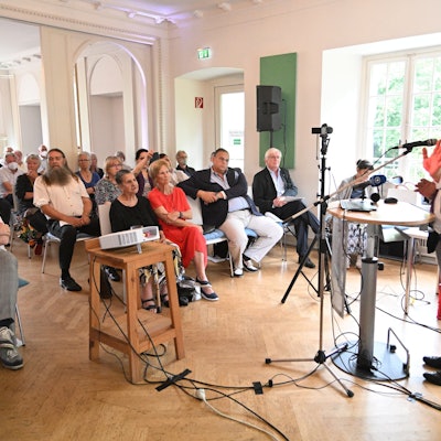Antiziganismus-Beauftragte Mehmet Gürcan Daimagüler hält eine Rede vor sitzendem Publikum im Schloss Eulenbroich.
