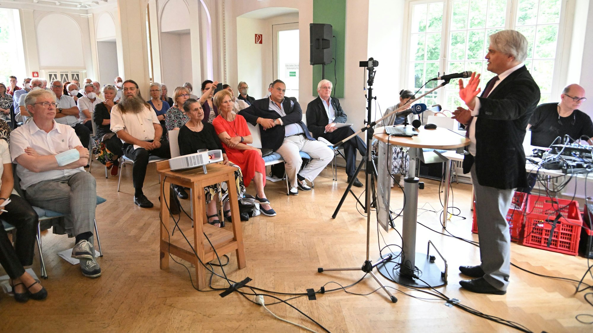 Antiziganismus-Beauftragte Mehmet Gürcan Daimagüler hält eine Rede vor sitzendem Publikum im Schloss Eulenbroich.