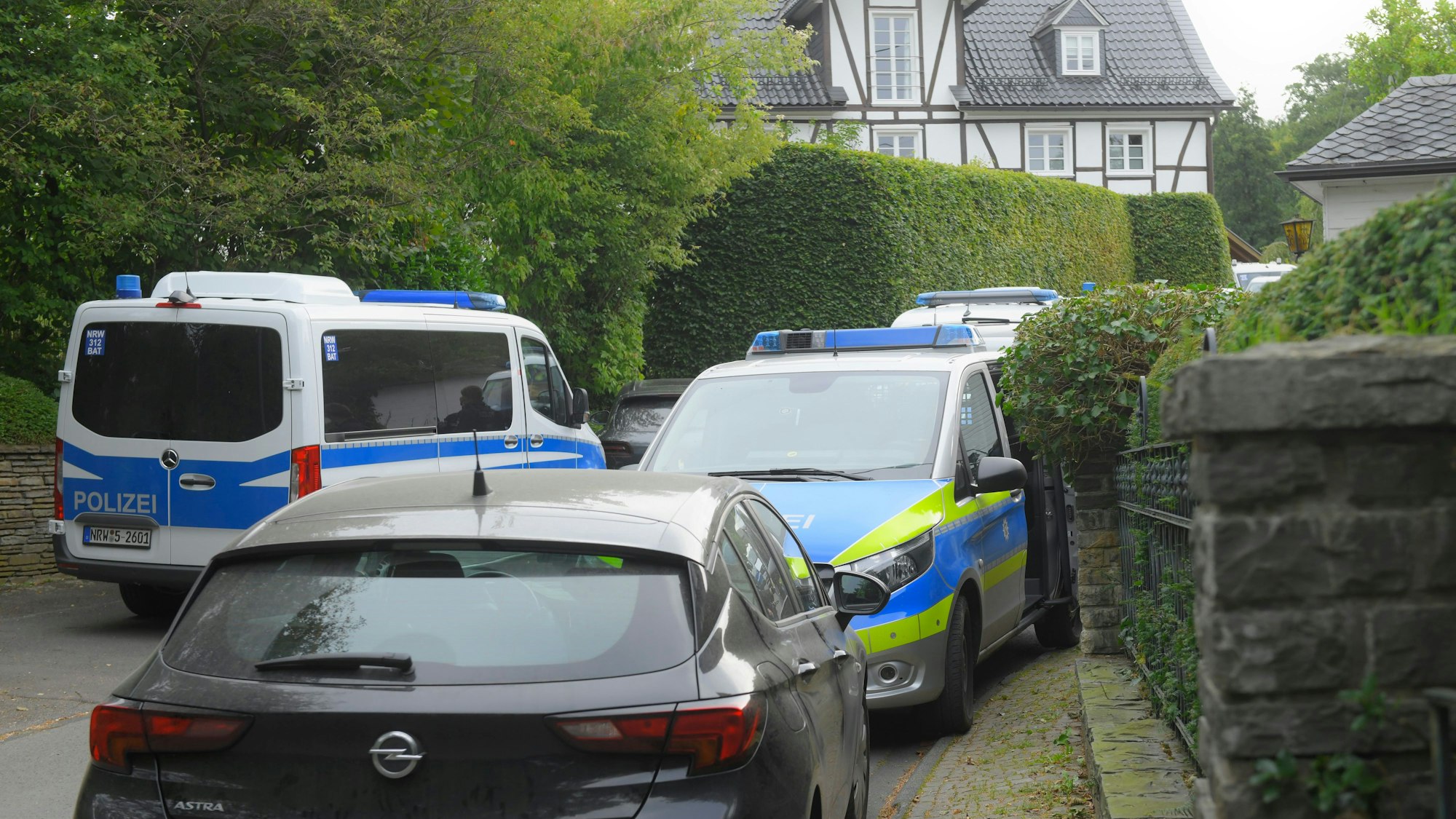 Polizeifahrzeuge sind in einer Zufahrt zu einem Gummersbacher Grundstück abgestellt. Ein Spezialeinsatzkommando durchsuchte das Anwesen im September 2020.