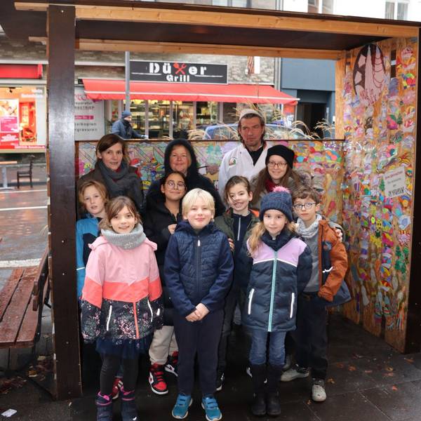 Das Bild zeigt Kinder vor einer Wunschkrippe und Bäckermeister Reiner Hütten.