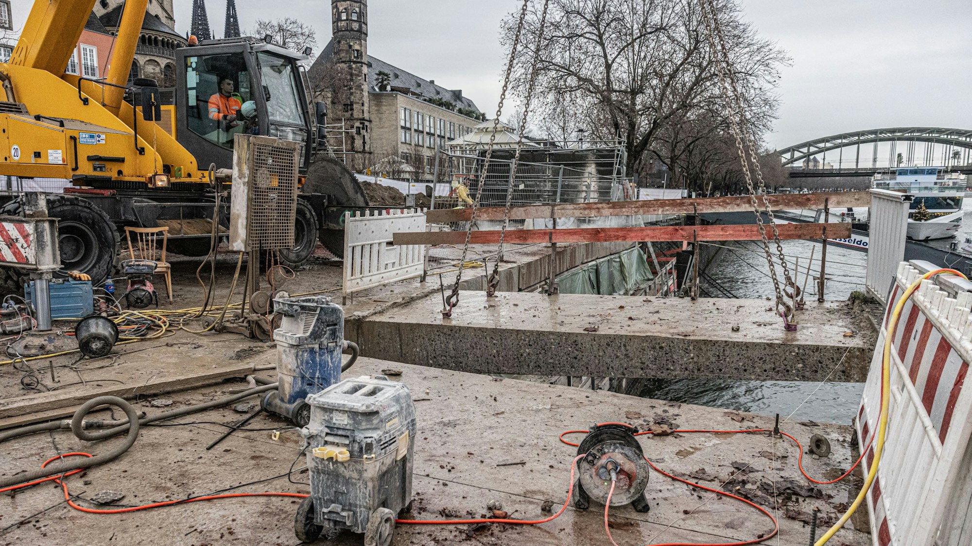 Während des Sägevorgangs wird das abzutrennende Teil an Ketten von einem Kran gehalten, damit es nicht in den Rhein fällt.