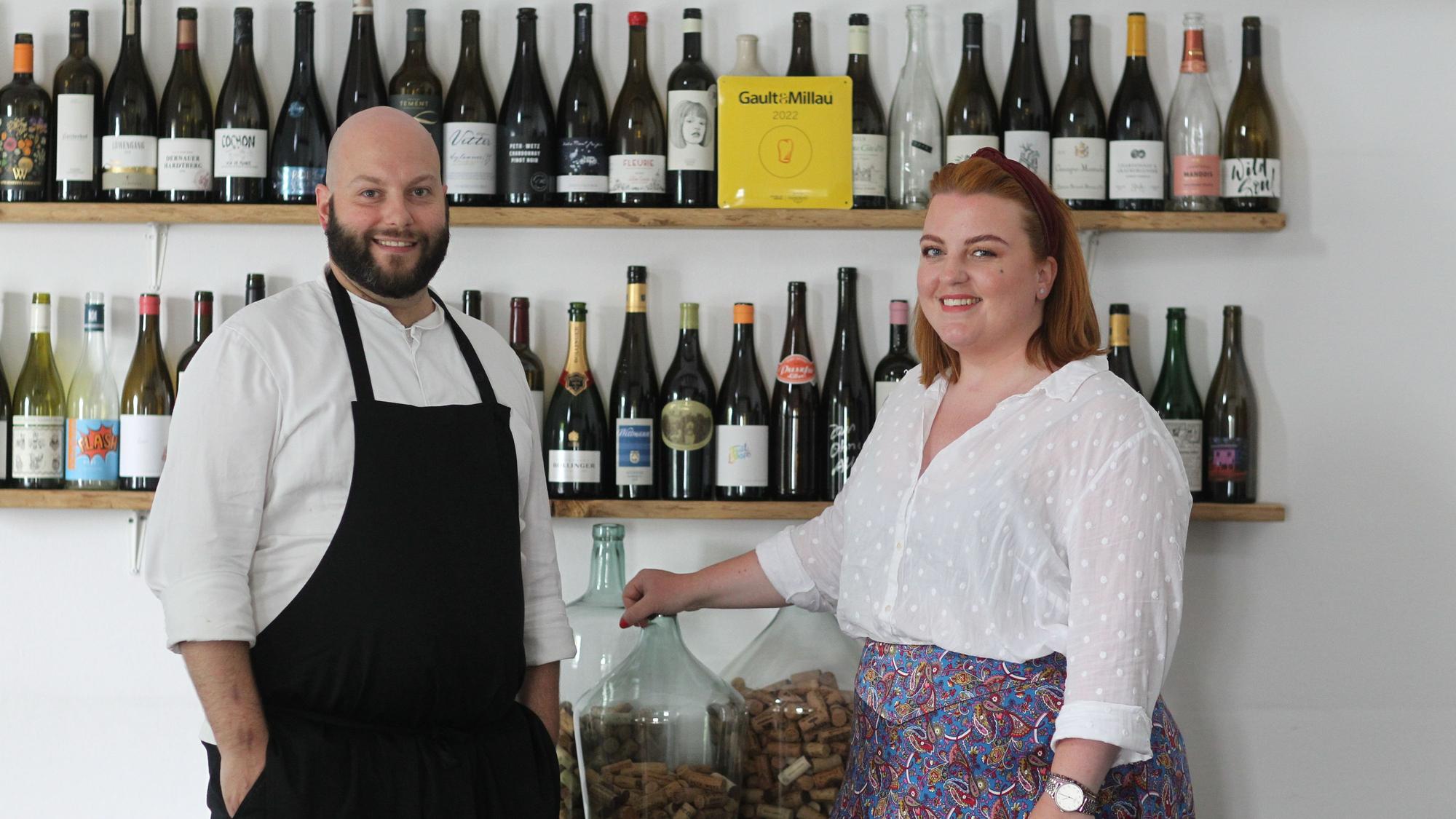 Daniel und Stephanie Lengsfeld aus dem Gasthaus Scheiderhöhe vor einer wand mit erlesenen Weinen.