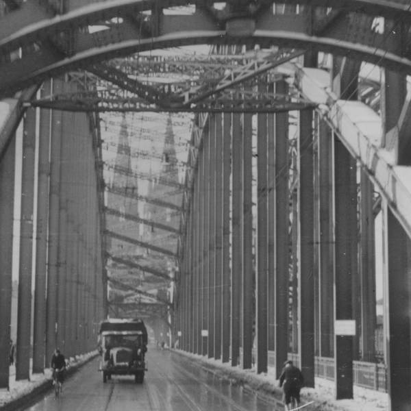 Ein schwarz-weißes Foto zeigt eine Brücke vor dem Kölner Dom