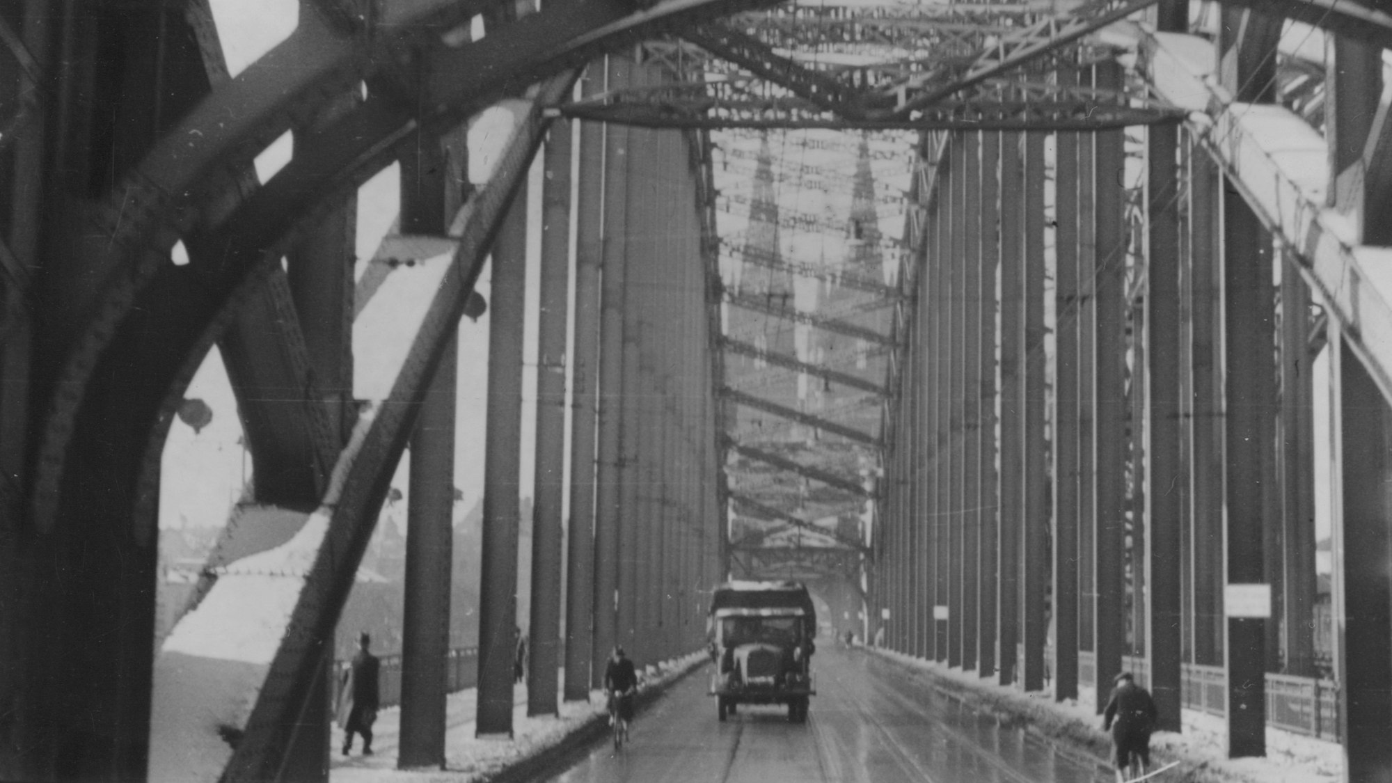 Ein schwarz-weißes Foto zeigt eine Brücke vor dem Kölner Dom