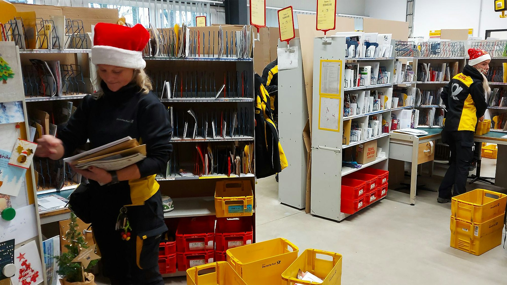 Sarah Vorstadt (vorne) und Nicole Wödl sortieren im Blankenheimer Verteilzentrum die Briefe, deren Anschriften die Lesemaschinen nicht entziffern konnten, per Hand. Und natürlich tragen sie an diesen Tagen rot-weiße Nikolauszipfelmützen.