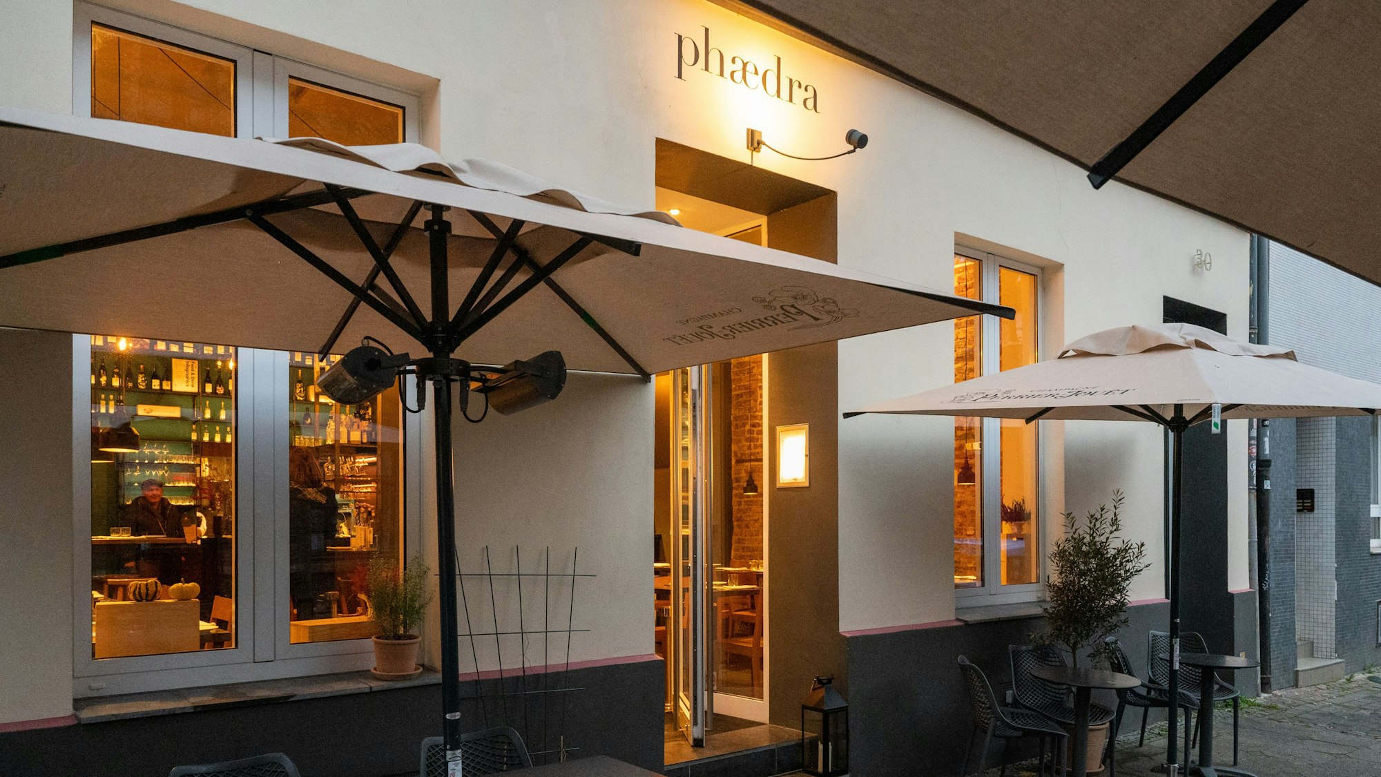 weißes Gebäude mit Blick in warm beleuchteten Innenraum