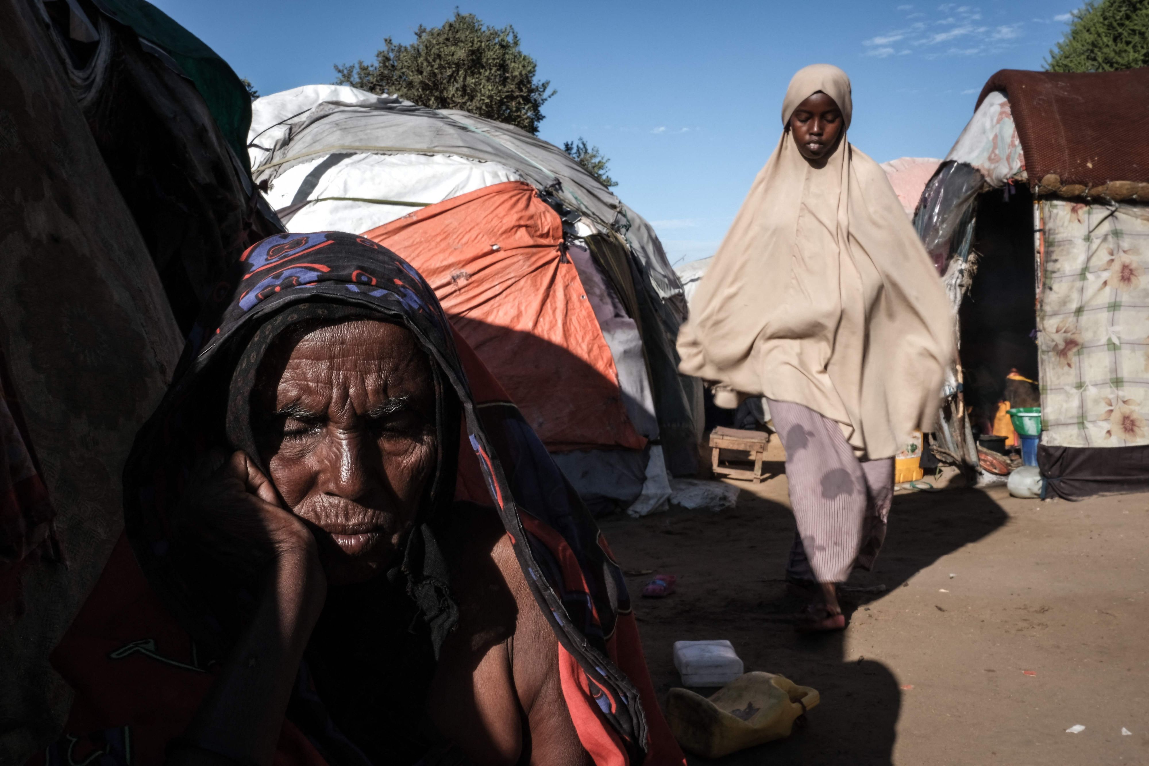 Ein Mann sitzt im Lager Limaan in Mogadischu, Somalia, vor einem behelfsmäßigen Zelt.