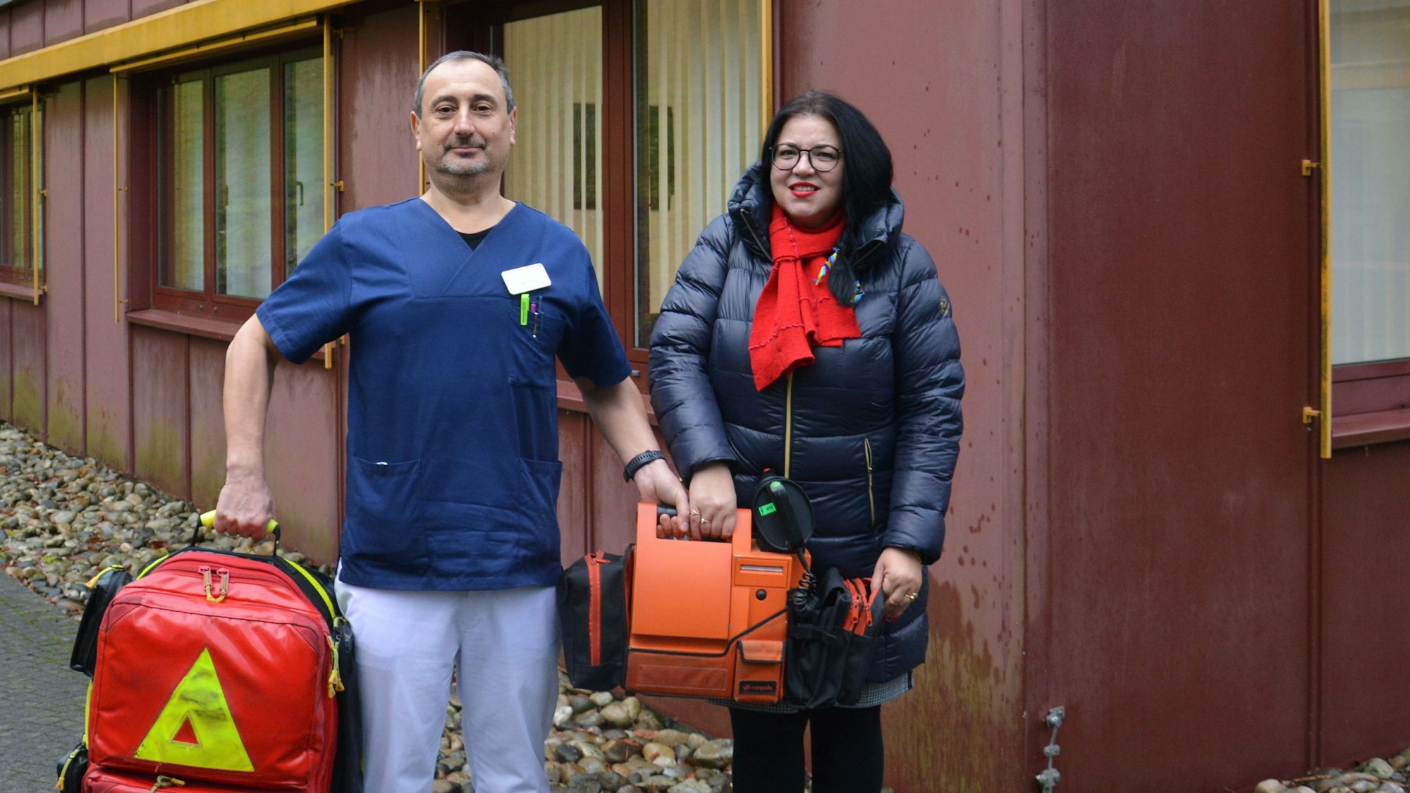 Valentyna Butulay und Igor Prudkov stehen mit medizinischen Geräten vor dem Krankenhaus in Gummersbach.