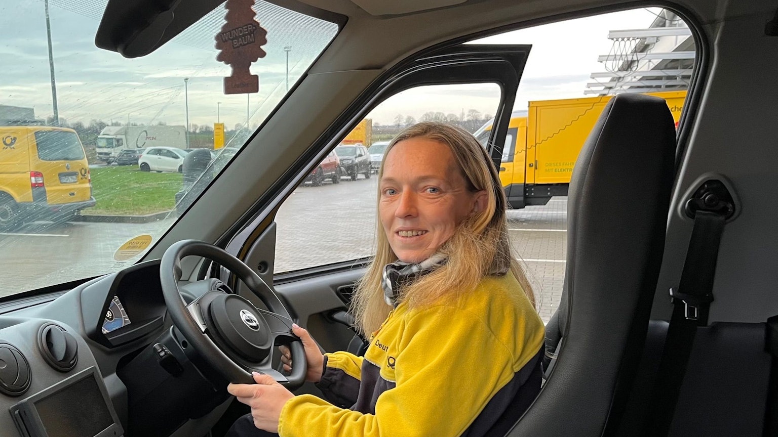Zustellerin Daniela Schwendtner sitzt in einem Postauto mit Lenkrad auf der rechten Seite