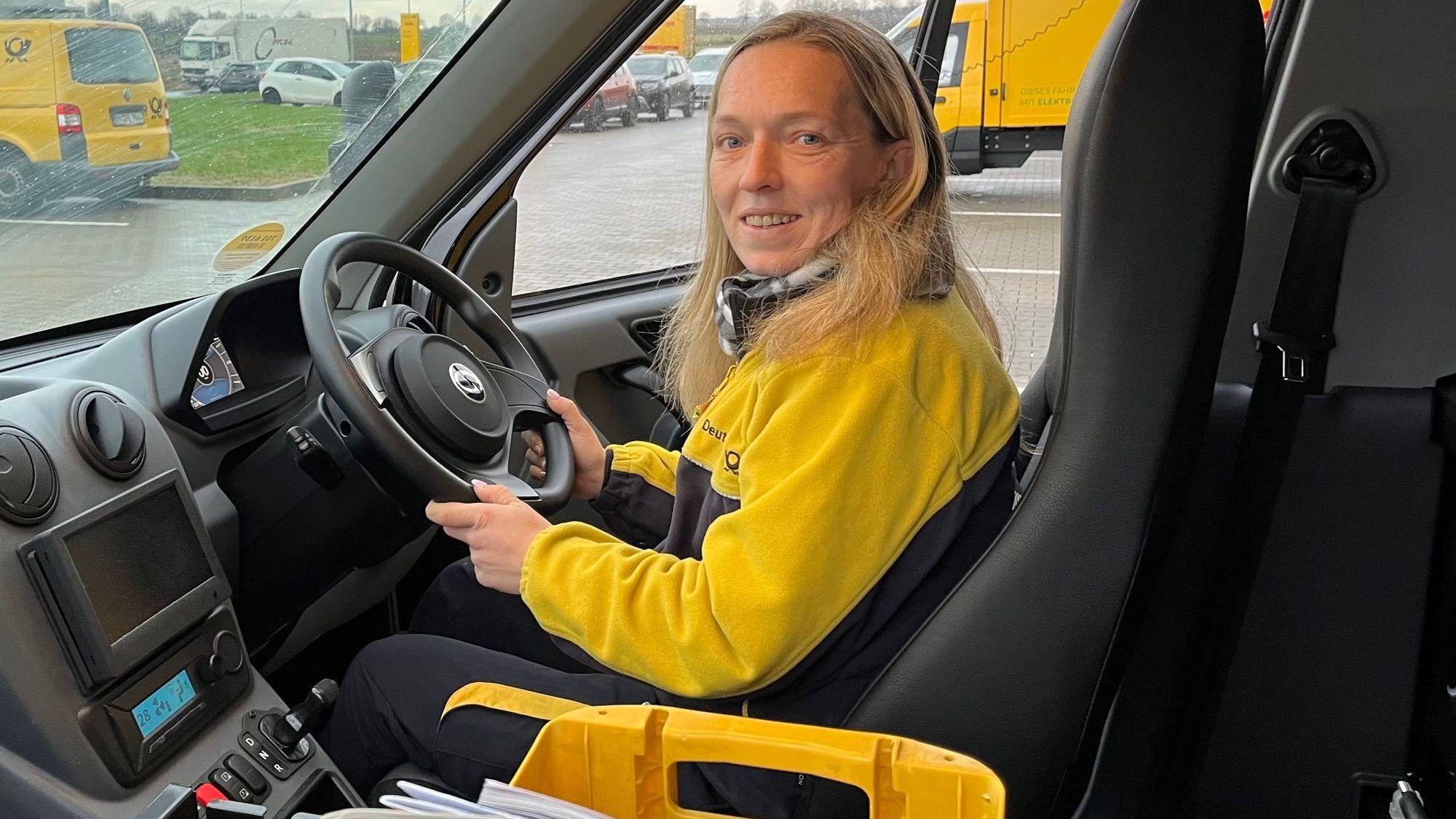 Zustellerin Daniela Schwendtner sitzt in einem Postauto mit Lenkrad auf der rechten Seite