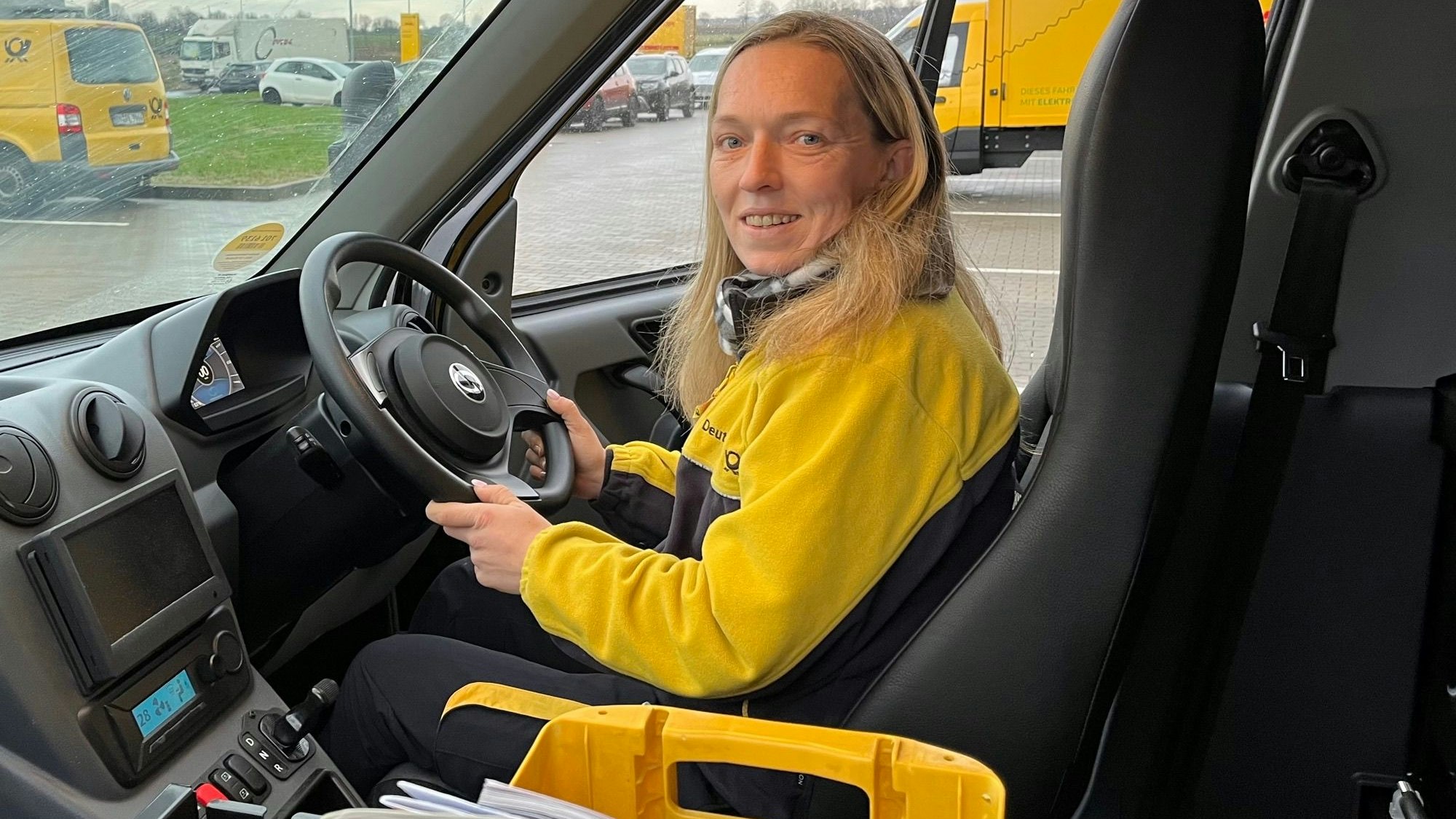 Zustellerin Daniela Schwendtner sitzt in einem Postauto mit Lenkrad auf der rechten Seite