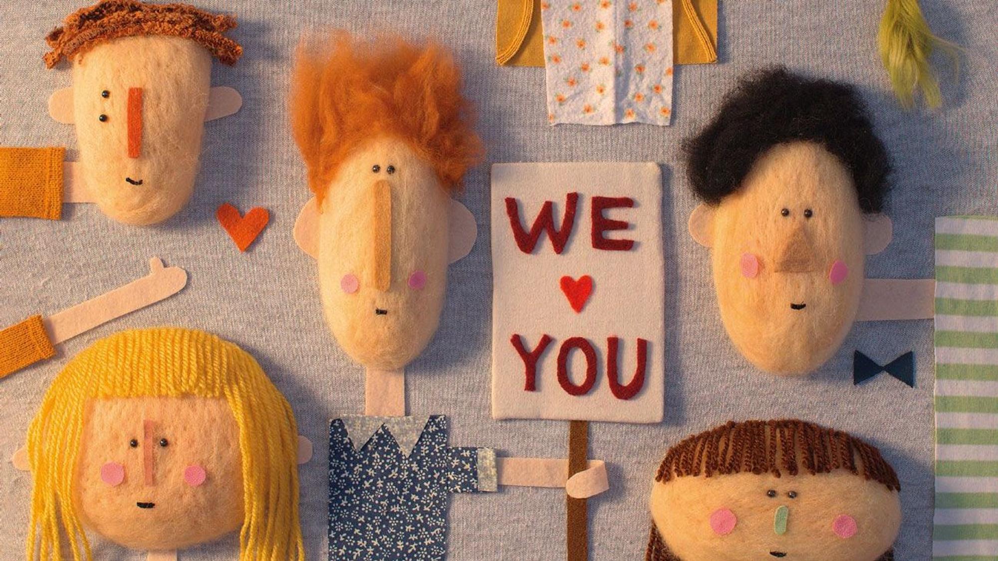 Viele Gesichter und ein Schild mit der Aufschrift We love You, Collage aus Stoff