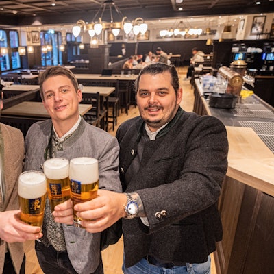 Im frisch renovierten Augustiner am Kölner Heumarkt stehen die drei Pächter Janis Leiro, Tobias Sudowe, Lasse Prumbaum. Der helle Holzboden und die dunkle Vertäfelung erinnern an die bayerische Brauhaus-Kultur.