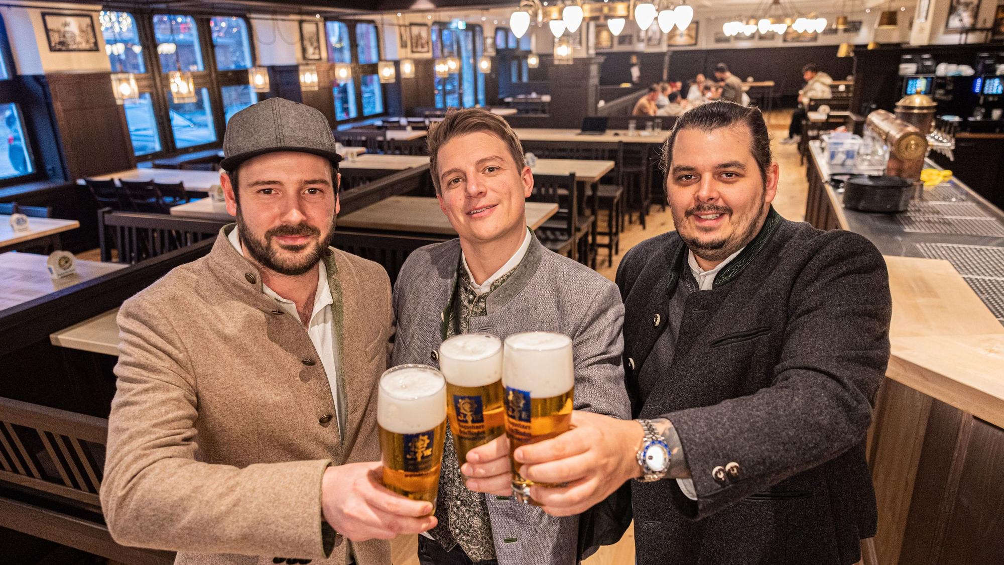 Im frisch renovierten Augustiner am Kölner Heumarkt stehen die drei Pächter Janis Leiro, Tobias Sudowe, Lasse Prumbaum. Der helle Holzboden und die dunkle Vertäfelung erinnern an die bayerische Brauhaus-Kultur.