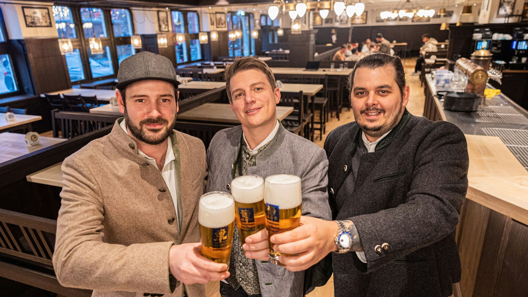 Im frisch renovierten Augustiner am Kölner Heumarkt stehen die drei Pächter Janis Leiro, Tobias Sudowe, Lasse Prumbaum. Der helle Holzboden und die dunkle Vertäfelung erinnern an die bayerische Brauhaus-Kultur.