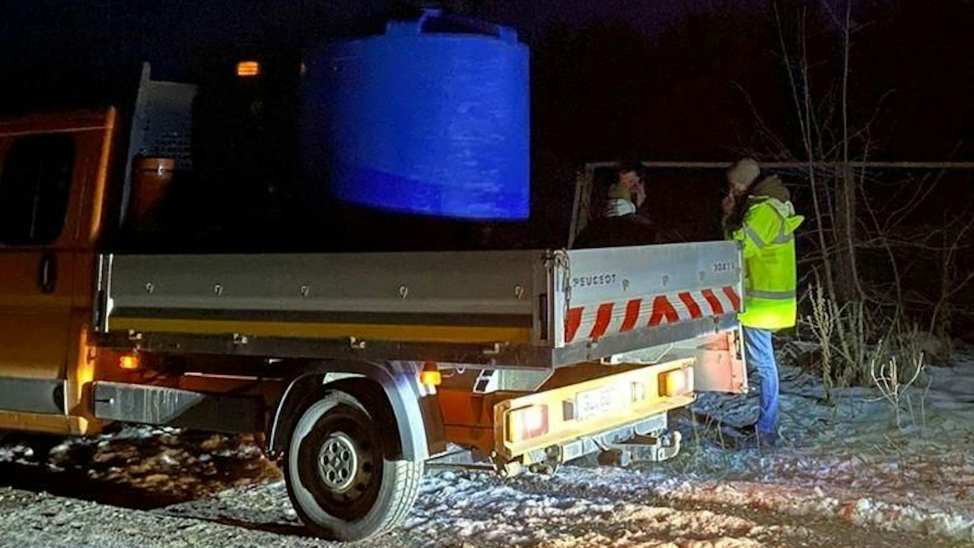 Ein Lastwagen mit Wasserkanister steht auf einer schneebedeckten Straße.