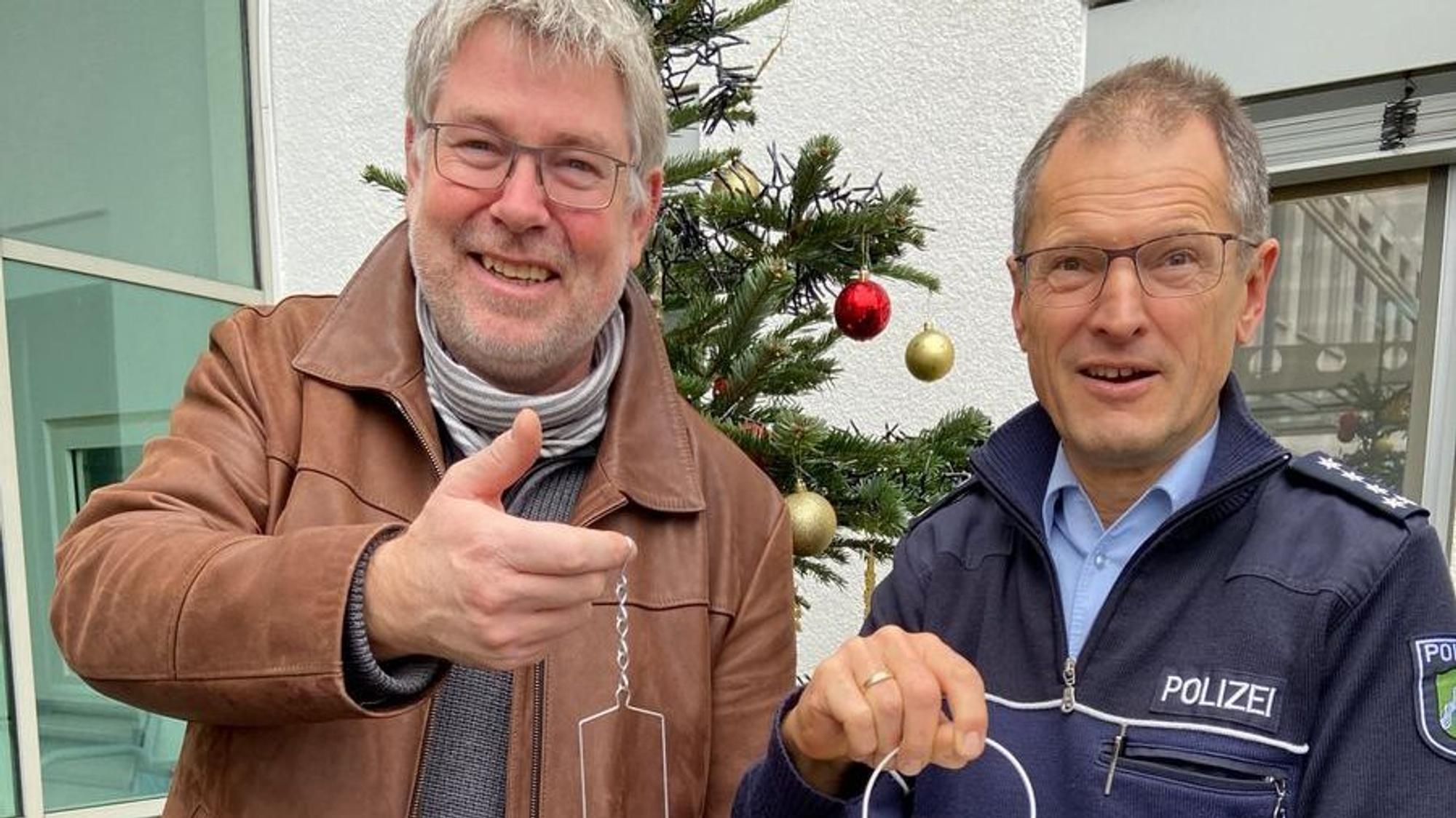 Zwei Polizeimitarbeiter haben leuchtende Laternen in der Hand.